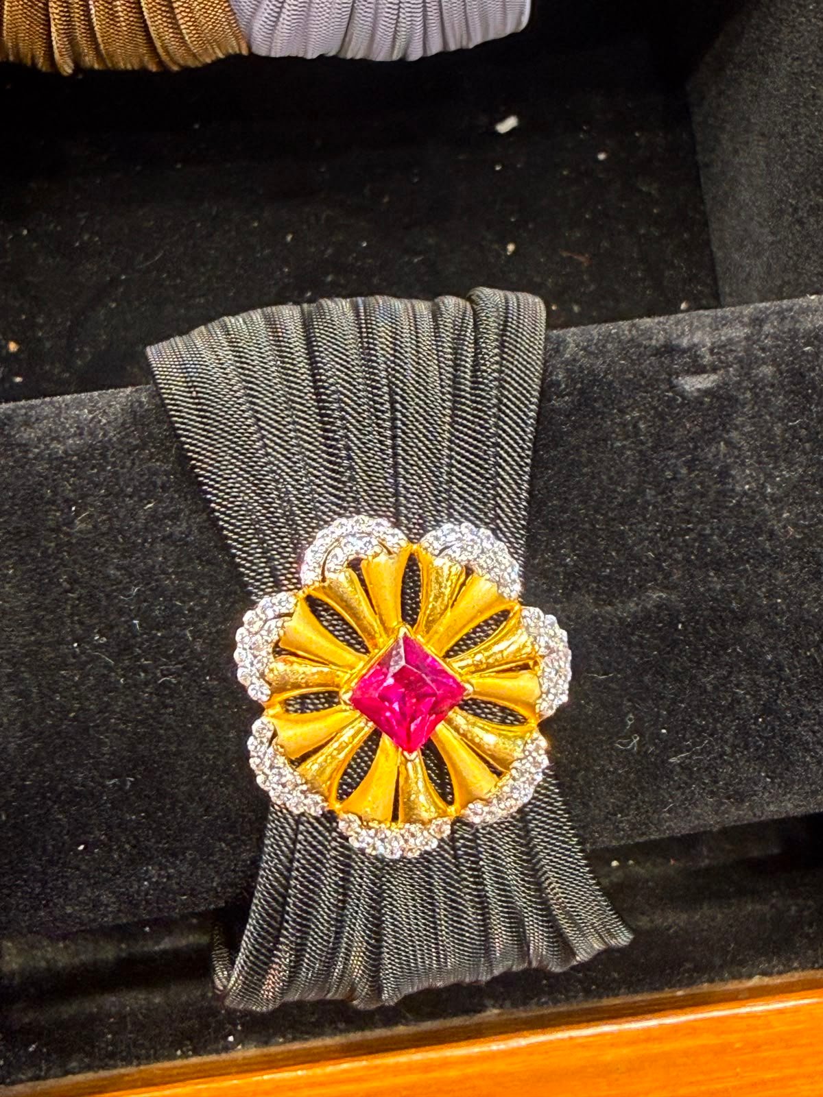 A gold pendant set with a ruby centre and a diamond border